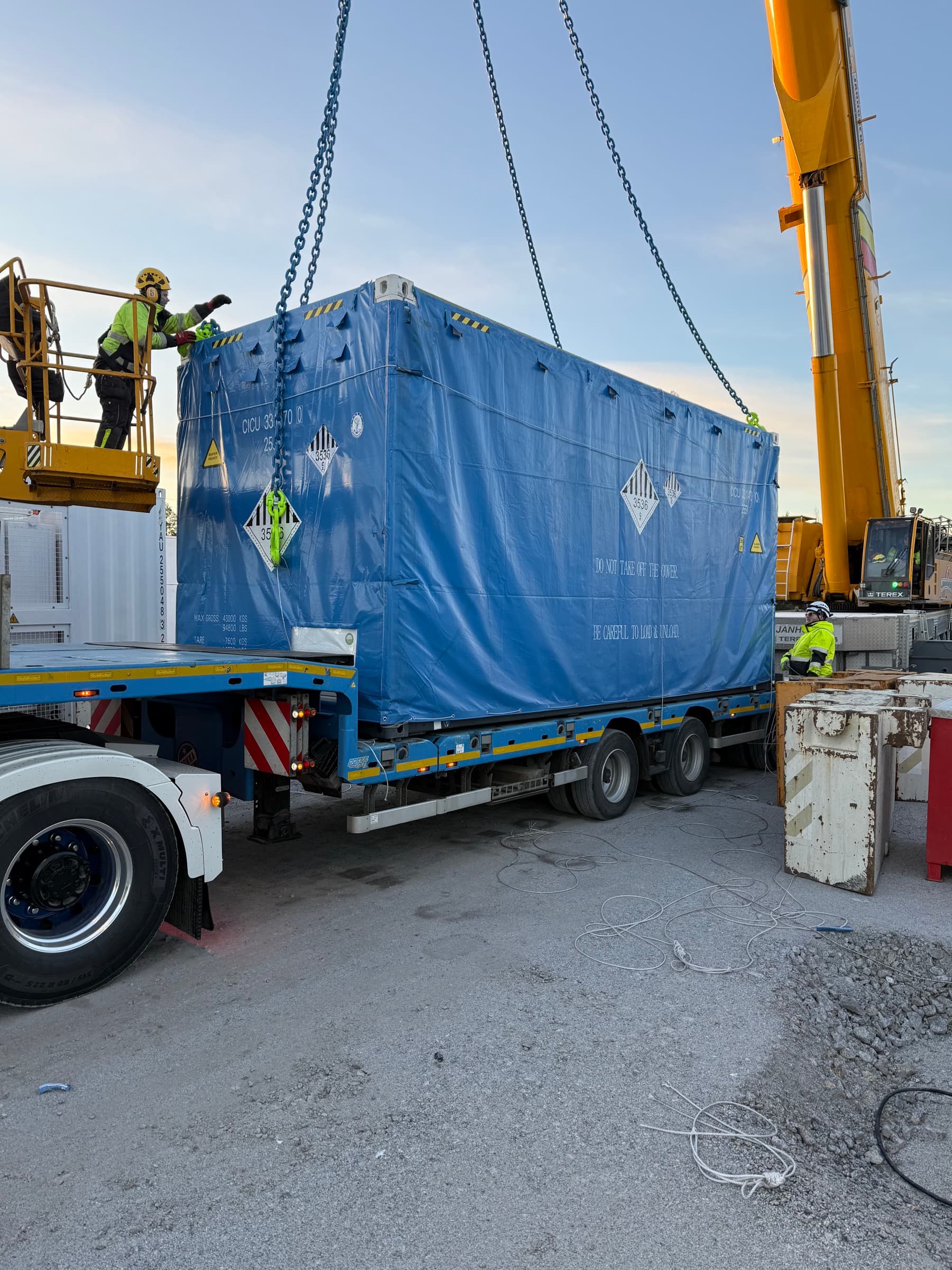 Battericontainer aflæsses fra lastbil med kran